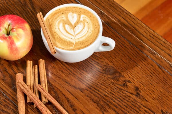 Hot Apple Cider Latte with an apple and cinnamon sticks