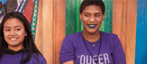 Two individuals in front of colorful background
